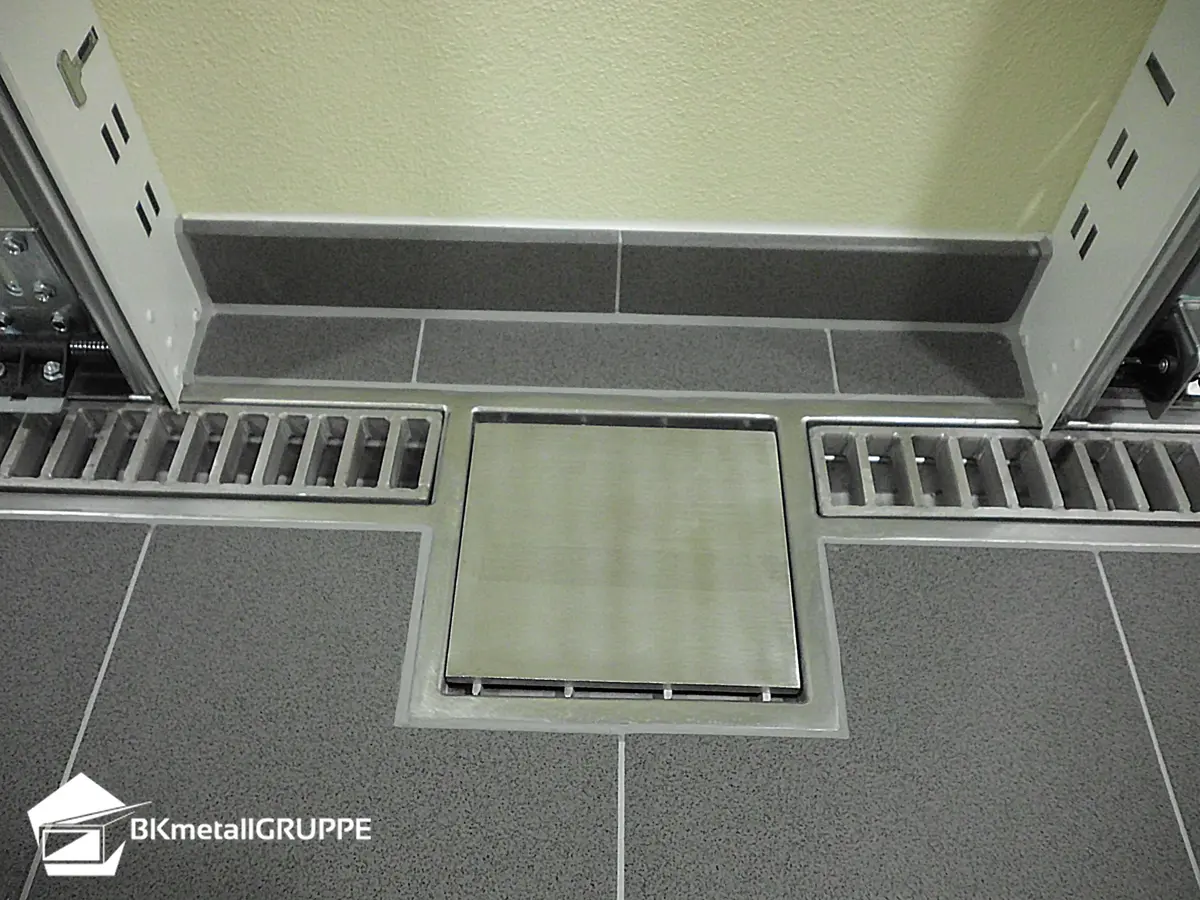 Canal de drenagem de garagem com tampa de escada e entrada com tampa de placa